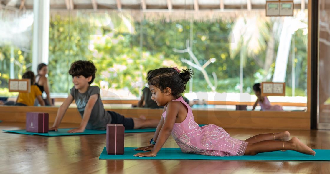 A Boy And Girl Sitting On The Floor Looking At A Tablet