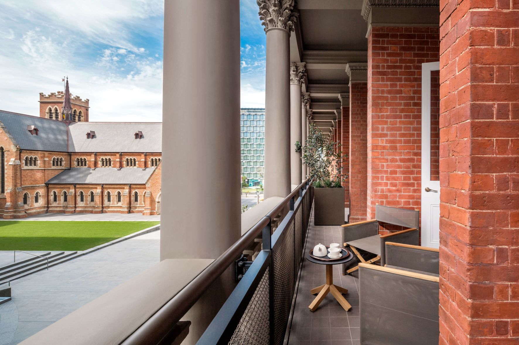 A View Of A Courtyard With Pillars And A Table