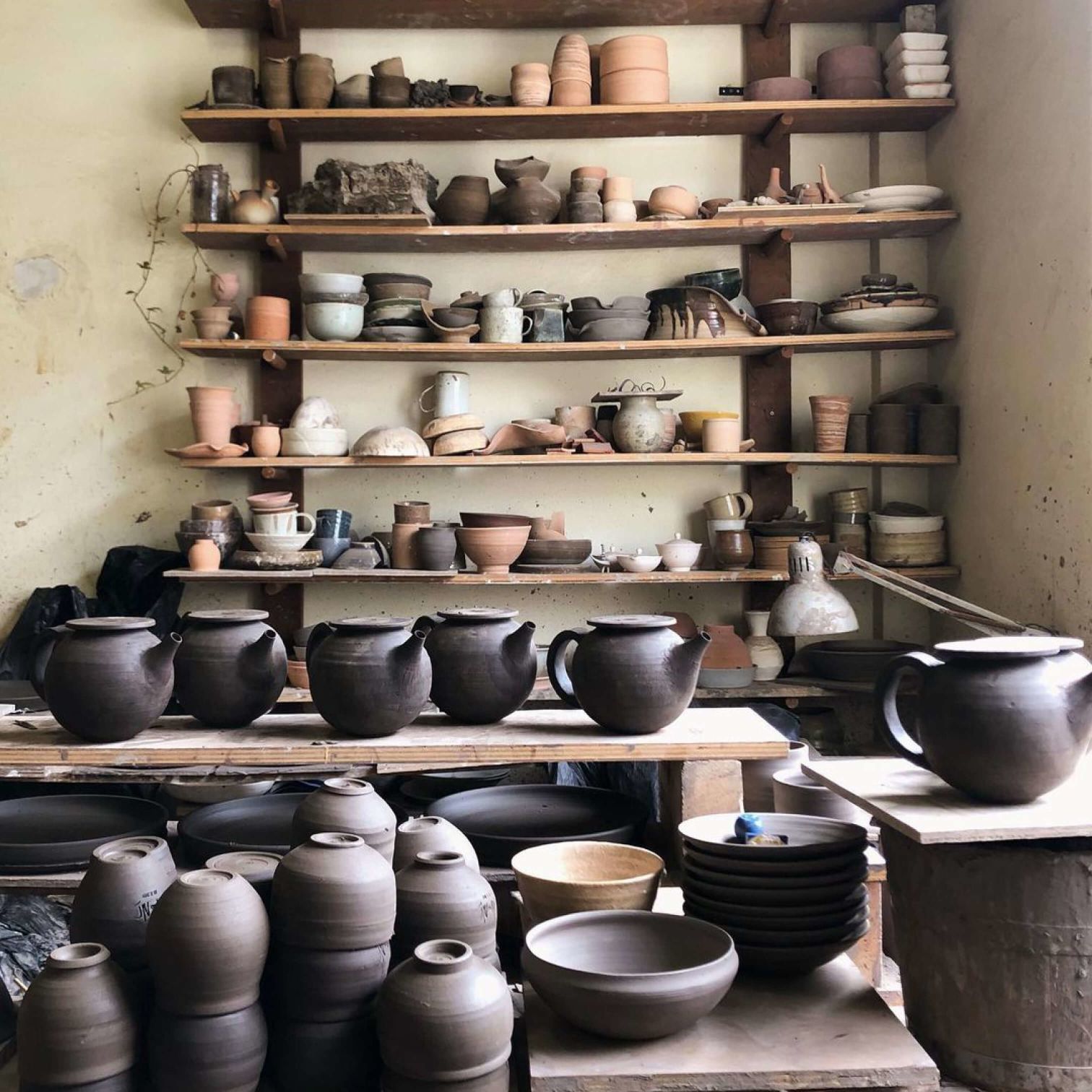 A Shelf With Many Pots And Pans On It