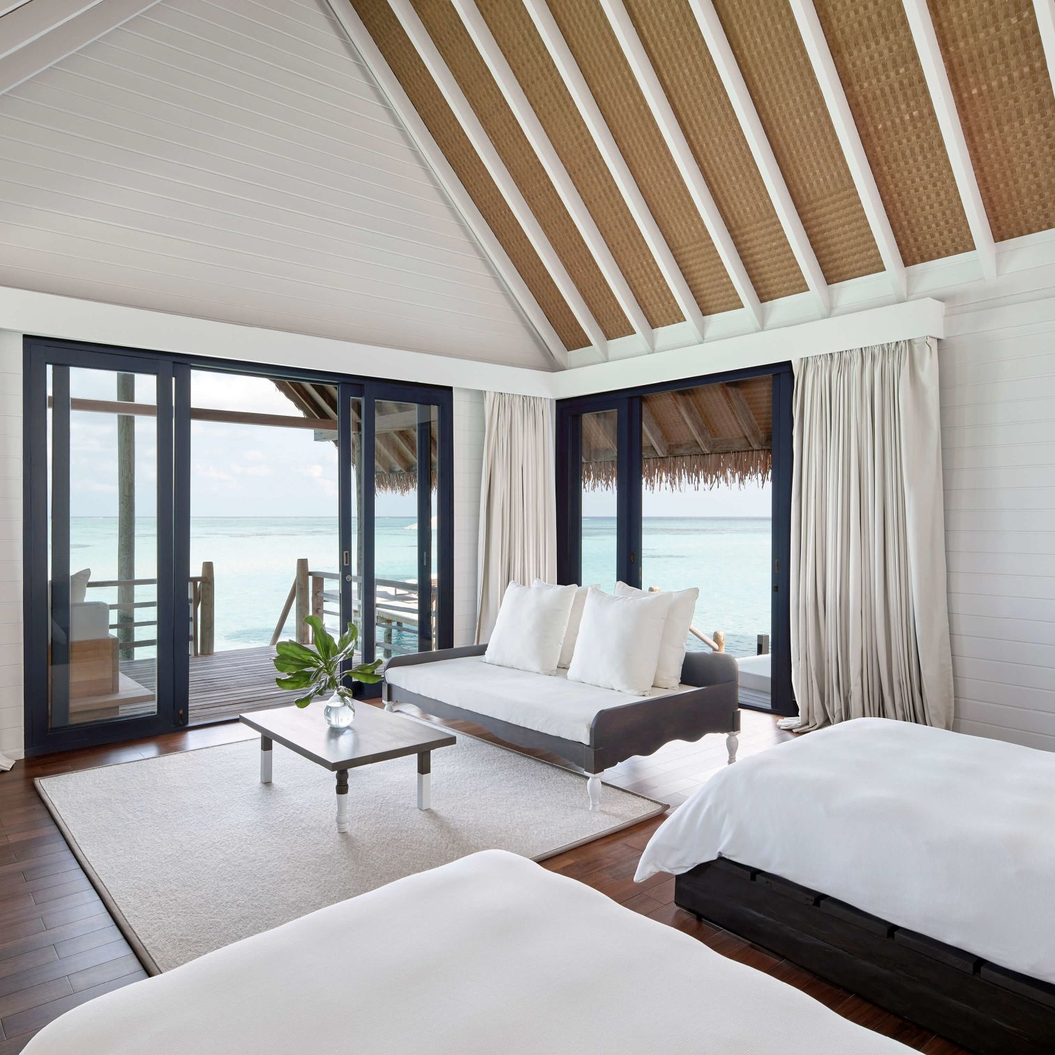 A Room With A Bed And A Table With A View Of The Ocean