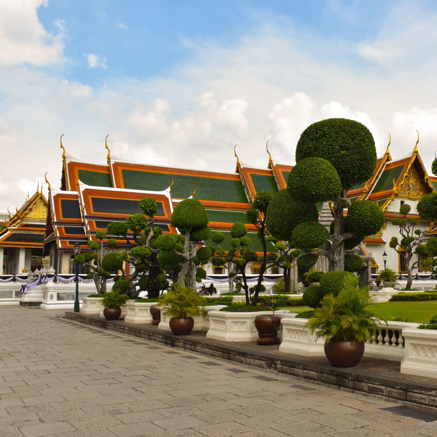 A Building With Trees And Plants In Front Of It