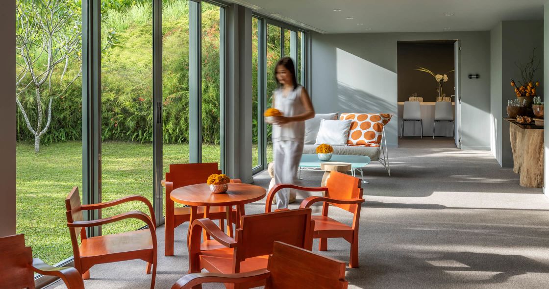 A Person Standing In A Room With A Table And Chairs