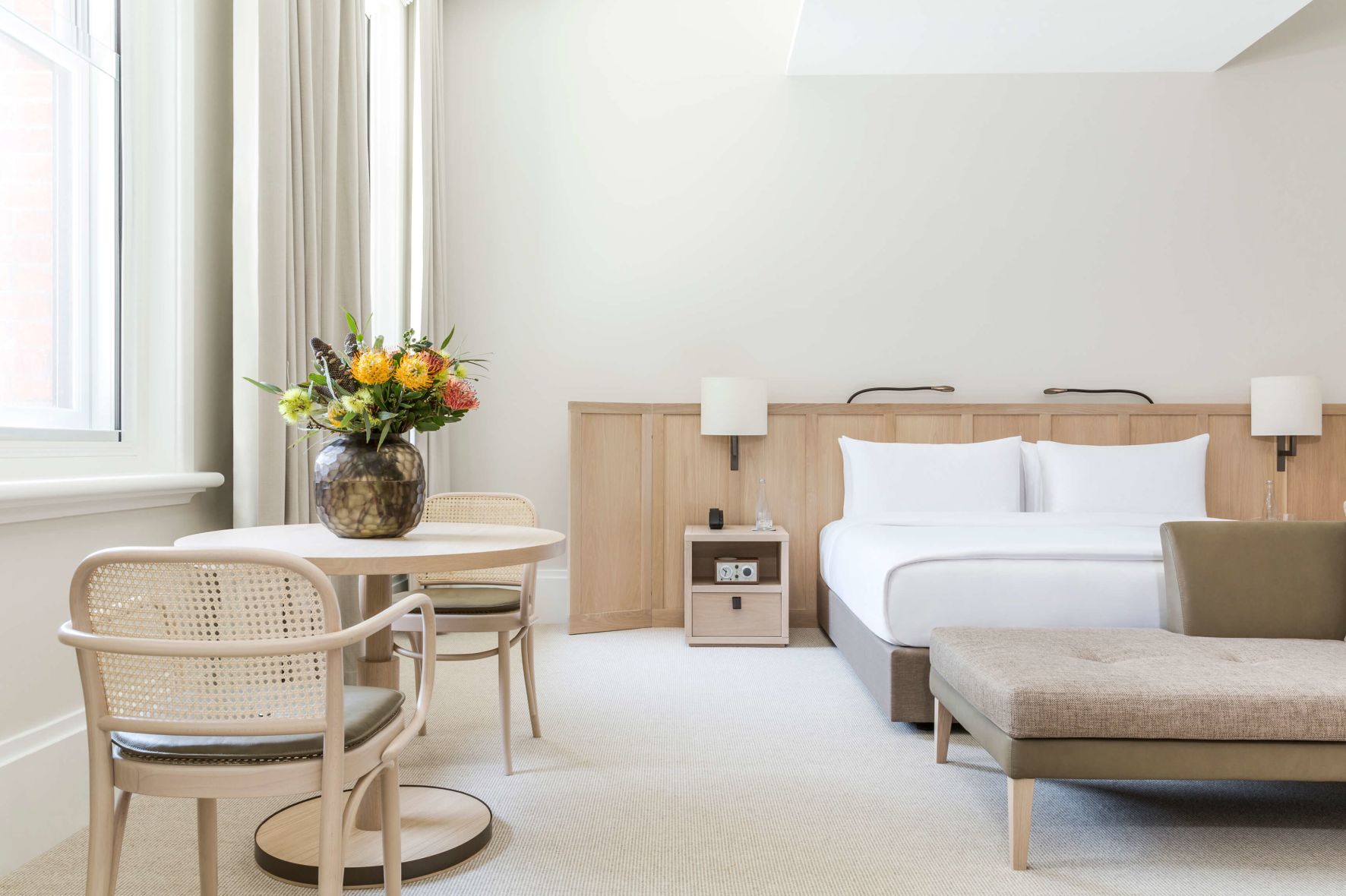 A Bedroom With A Bed And Chairs