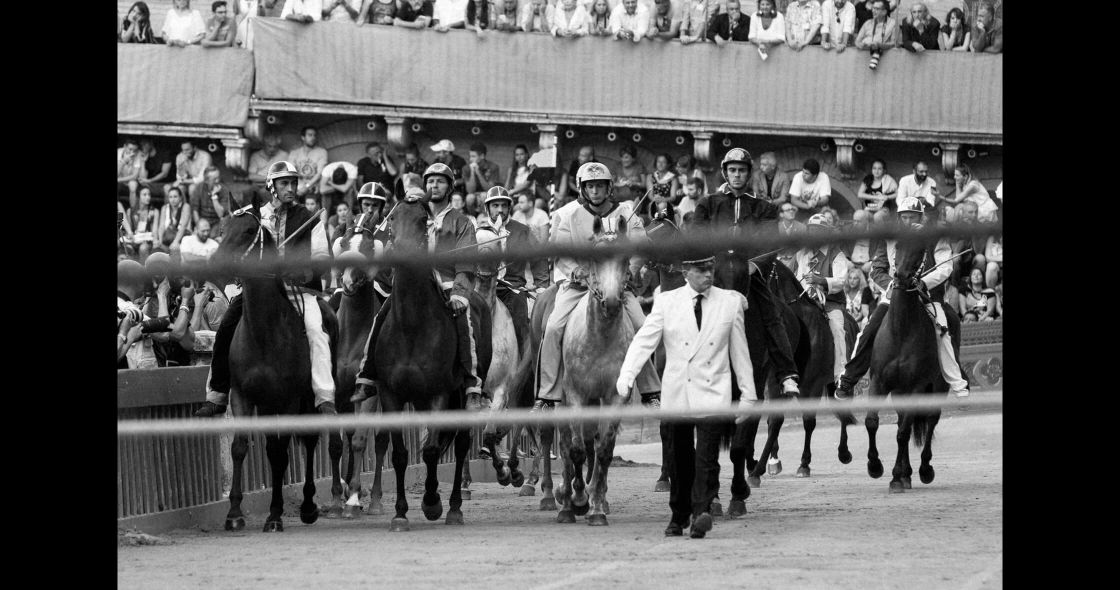 A Group Of Men Walking With Horses