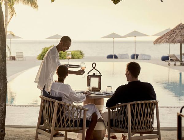 A Group Of People Sitting At A Table Outside