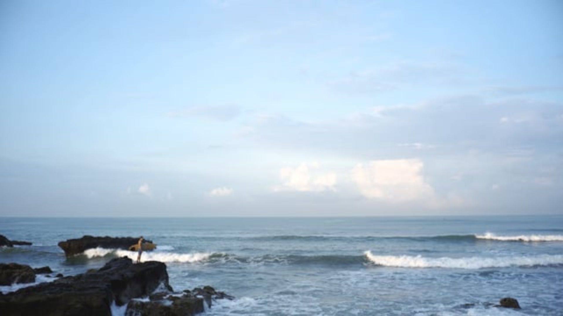 A Body Of Water With Rocks And A Blue Sky