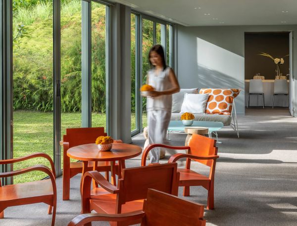 A Person Standing In A Room With A Table And Chairs