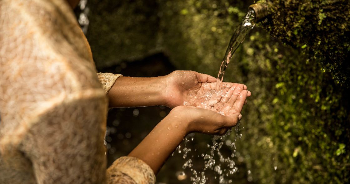 A Pair Of Hands Holding A Water Droplet