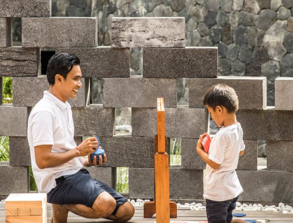 A Person And A Boy Playing With A Toy