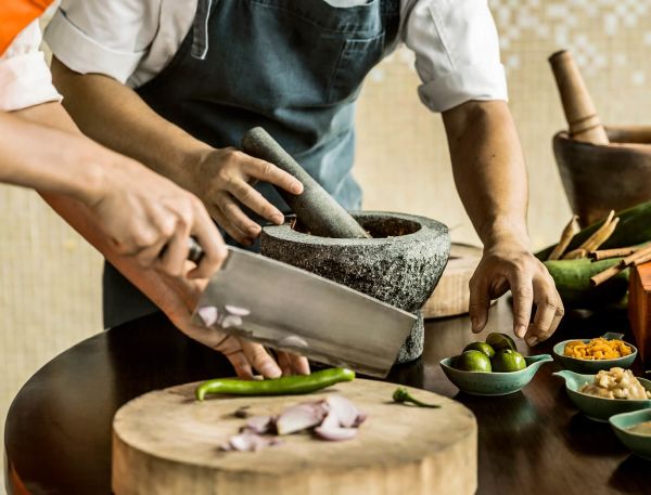 A Couple Of People Cutting Up Food