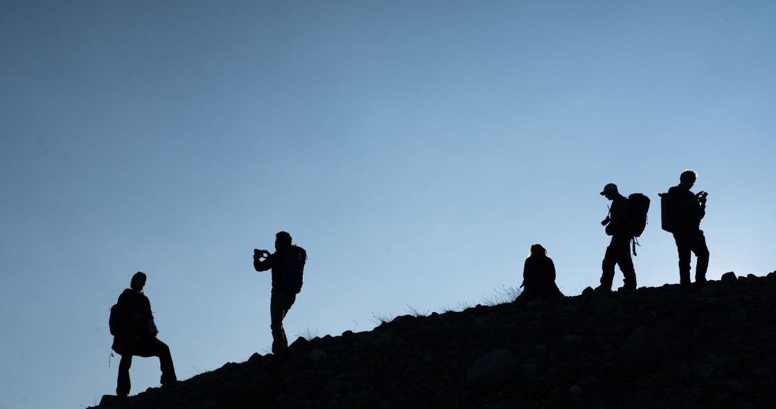 A Group Of People Standing On A Rocky Hill