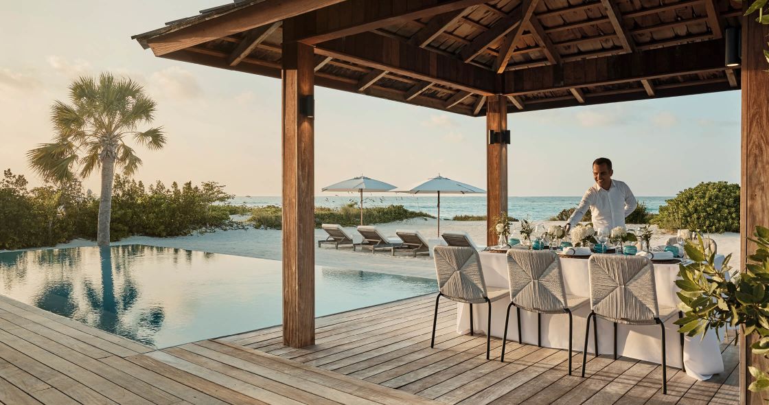 A Person Standing On A Deck Next To A Pool