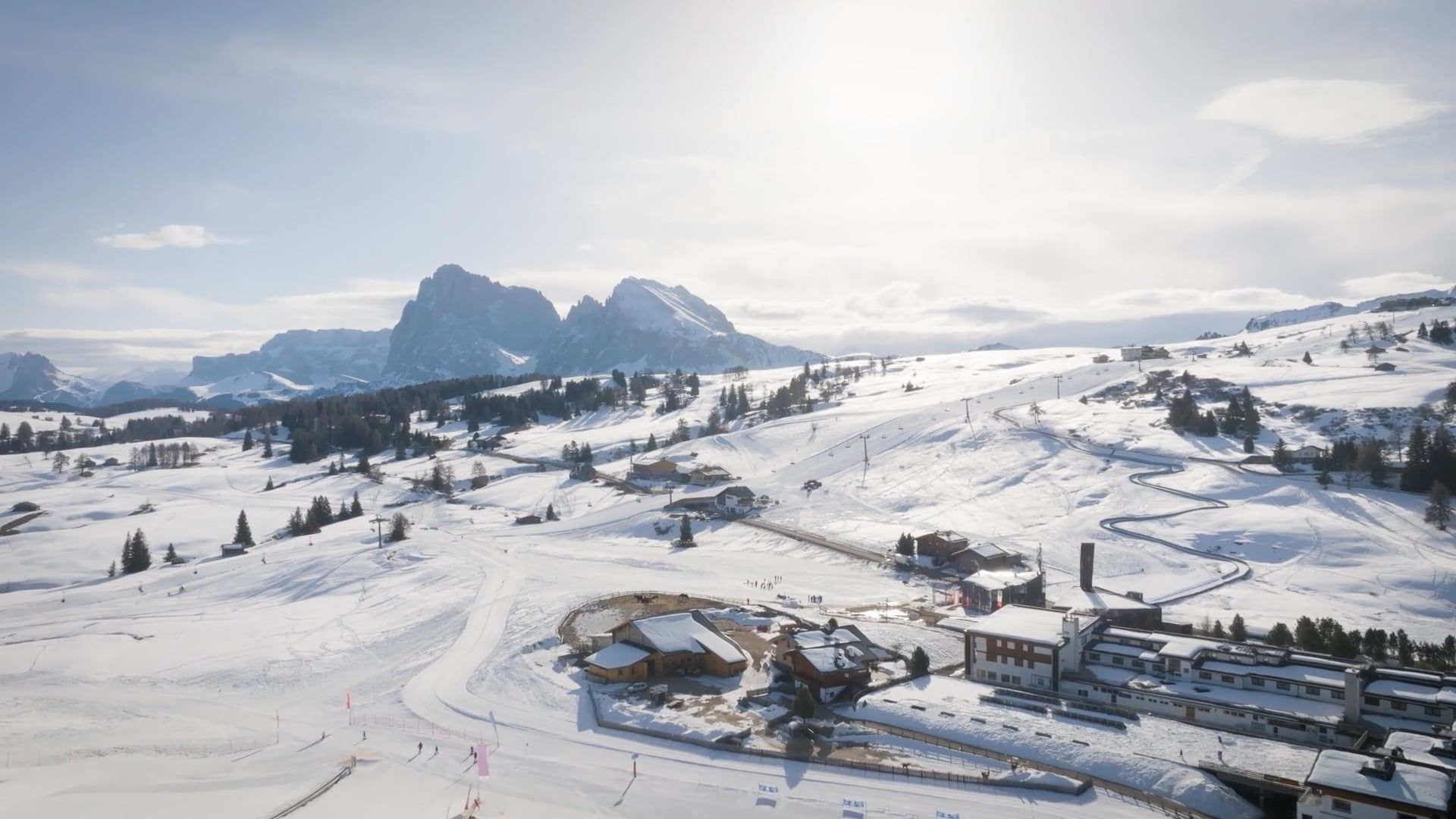 A Snowy Landscape With Buildings And Mountains