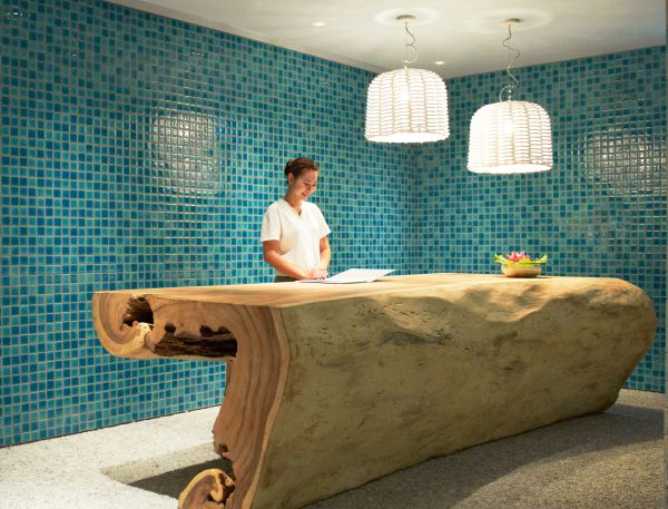 A Person Standing Behind A Large Wooden Bathtub In A Bathroom