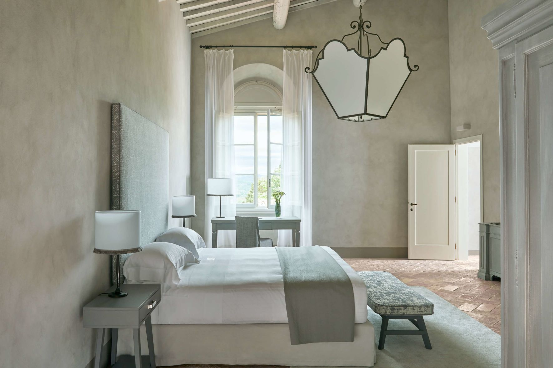 A Bedroom With A Bed And Lamps