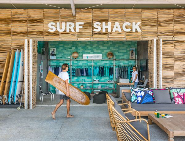 A Person Carrying A Surfboard
