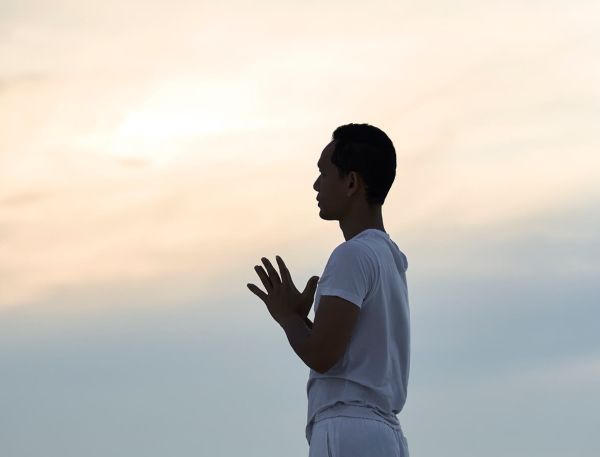A Man Standing In Front Of A Cloudy Sky