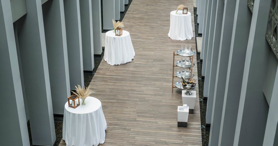 A Wooden Walkway With Tables And Chairs